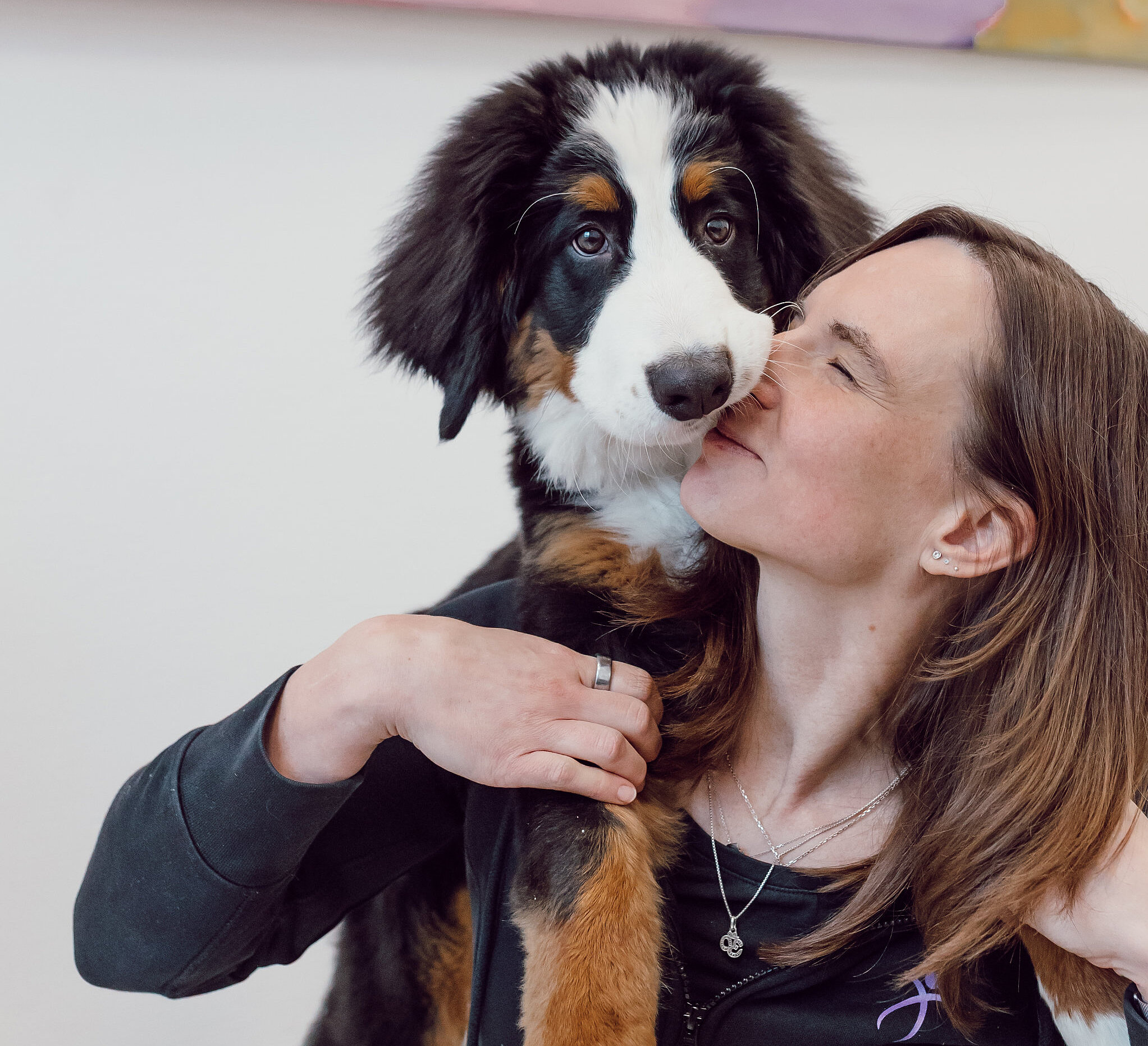 Ansprechpartnerin für Osteopathie, Nicole Amoussou, kuschelt mit einem Hund auf ihren Schultern