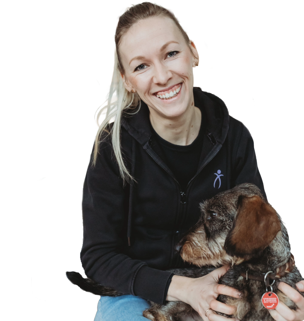 Tierphysiotherapeutin Anna-Lena Heitkötter mit einem Hund in den Armen